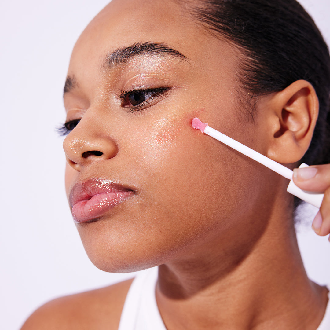 model applies pH Oil to her cheek